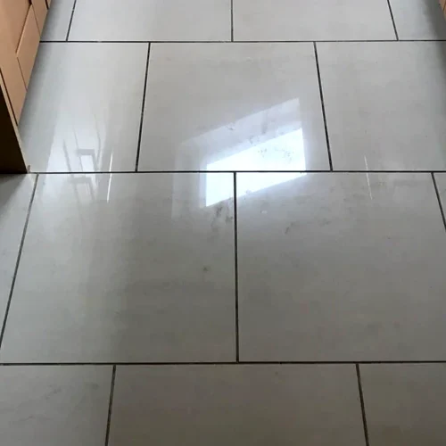 Cream polished porcelain kitchen floor that looks slightly dull and smeary